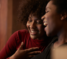Two women smiling and hugging.